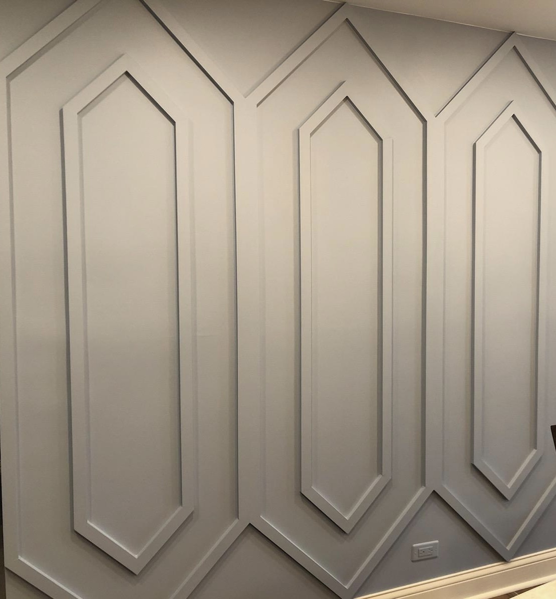 A tan accent wall designed by an interior designer for a client. The wall features raised panels.